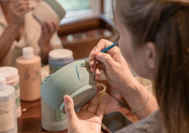 A person painting a bowl.