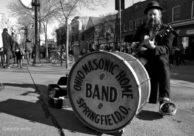 Boo Mullarky busking with a large drum and resonator guitar.