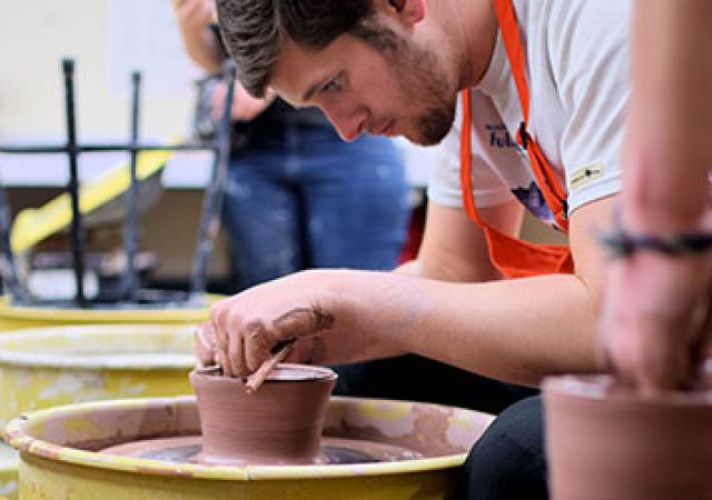 Artist carefully making a pot on a spinning wheel