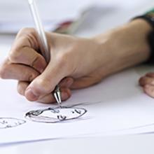 Closeup of someone drawing a face with a pen