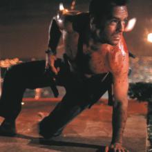 Still from film Die Hard (1988), Man with gun ducks behind explosion.