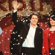 Still from film Love Actually, man and woman stand in Christmas attire as snow falls.