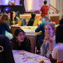 three people smiling with food in front of them and colorful background