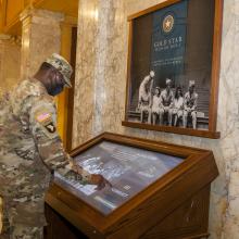 service member stands at electronic Gold Star Honor Roll in Memorial Hall, outside of Main Lounge at Memorial Union