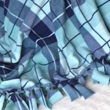 blue plaid tie blanket draped on ground