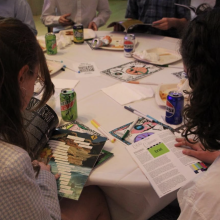 Students sit at table and read magazines together