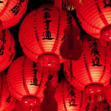 Picture that shows red paper Chinese laterns glowing with Chinese lettering on them 
