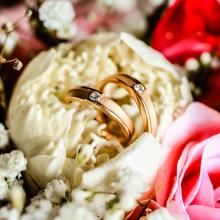Wedding bands staged in a bouquet of flowers. 