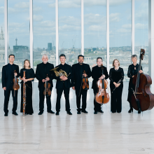 Academy of St Martin in the Fields Octet standing in front of a skyline.