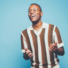Michael Mayo standing in front of a blue background.