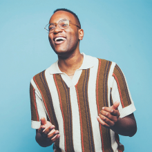 Michael Mayo standing in front of a blue background.