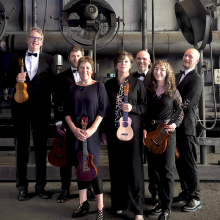 Ukulele Orchestra of Great Britain posed in an industrial setting.