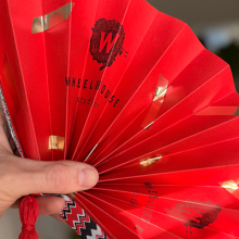 Photo of a crafted red folding fan.