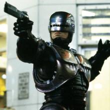cyborg holding up a weapon