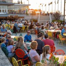 An audience of seated patrons enjoys live music on the Terrace at sunset.