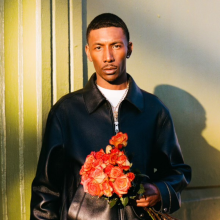 blAck pARty holding a bouquet of flowers against a sunlit background.