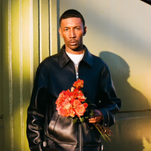 blAck pARty holding a bouquet of flowers against a sunlit background.