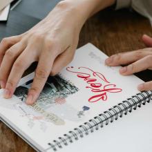 Photo of someone working in a journal notebook. 