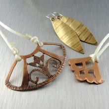 Photo of three different pieces of jewelry made from metal. 