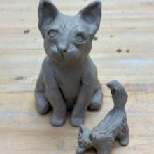 Photo of two cats made from hand building clay. 