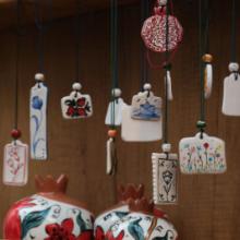 Photo of several handcrafted ceramic pendants hanging. 
