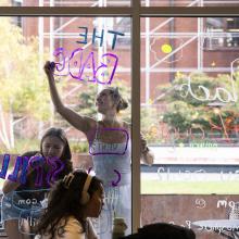 Students painting windows at Memorial Union for Homecoming celebration