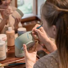 A person painting a bowl.
